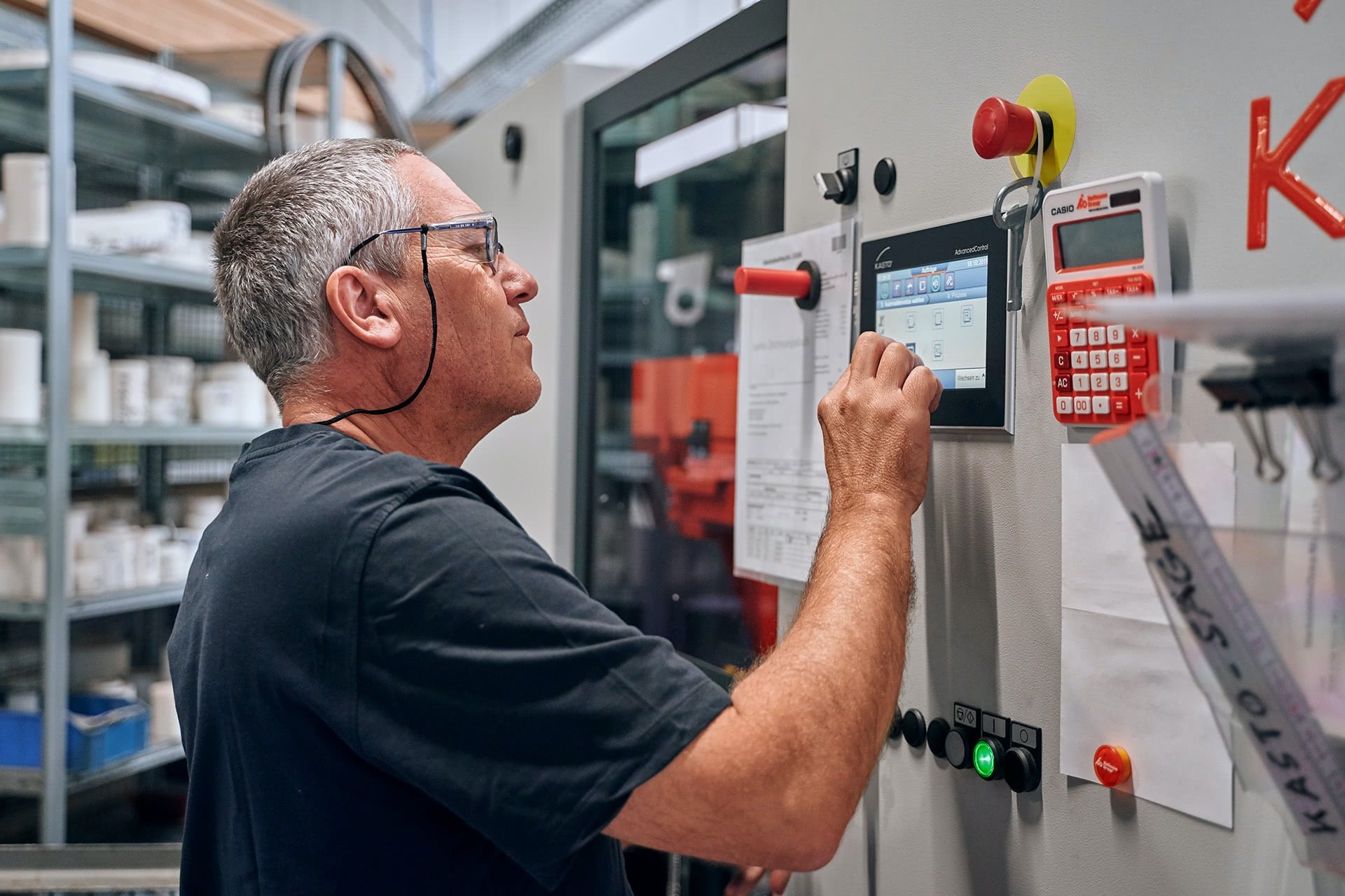 Ein Mitarbeiter bedient den Touchscreen einer Maschine