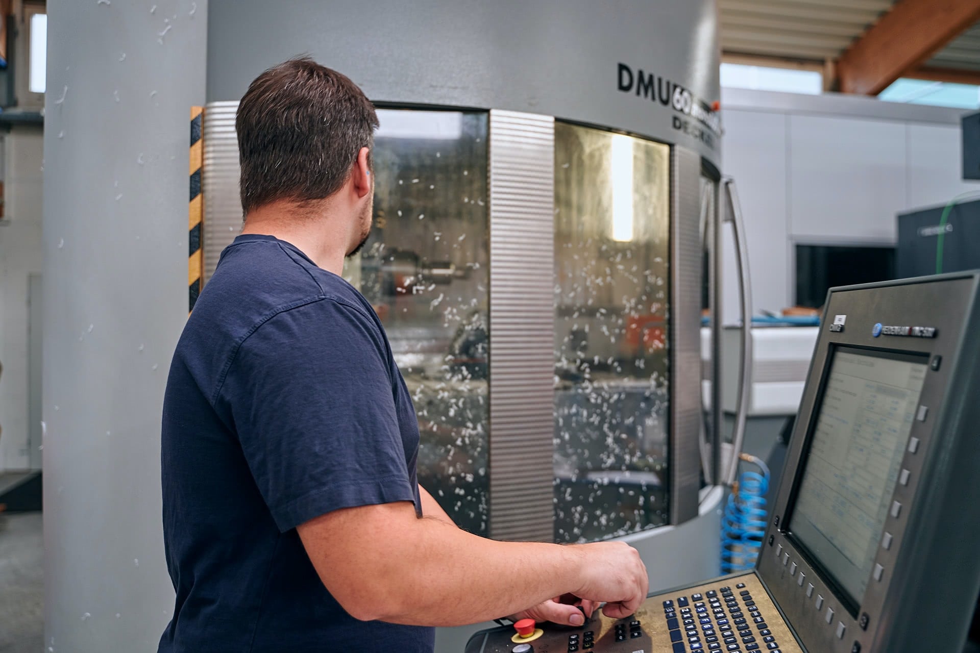 Ein Mitarbeiter bedient eine Maschine in der Produktion