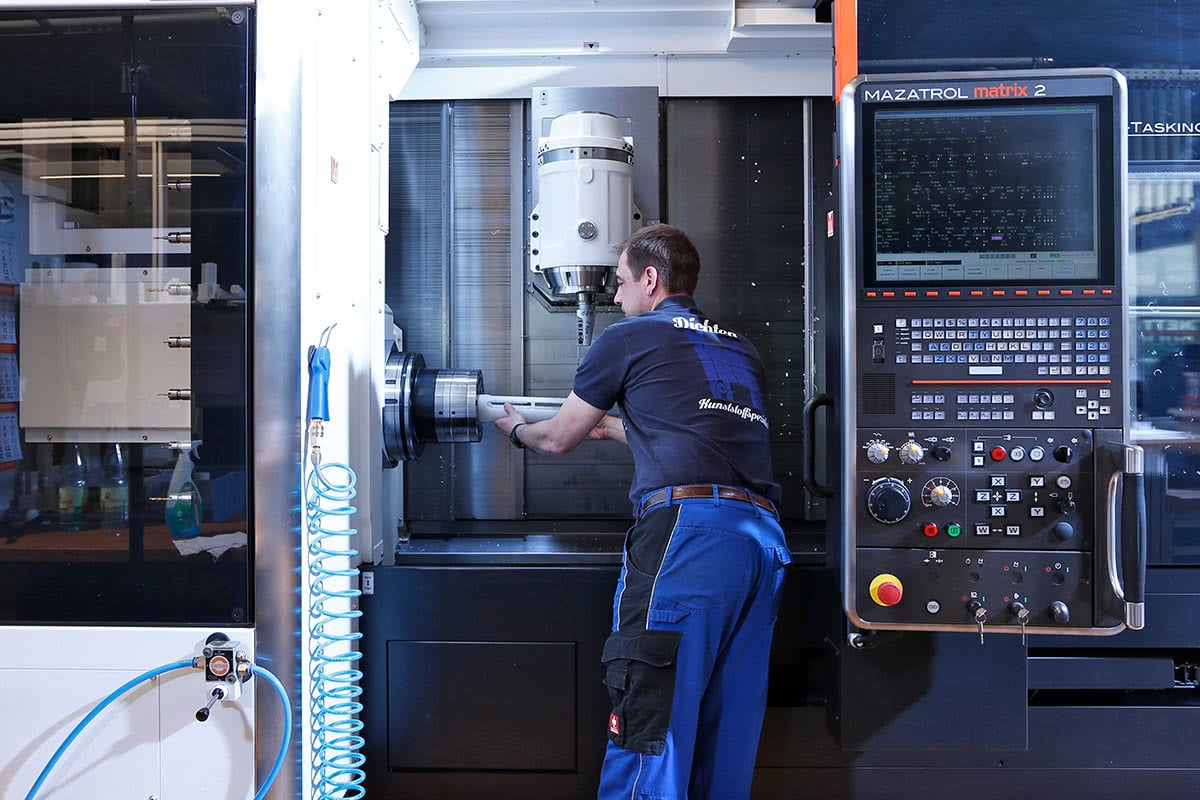 Ein Mitarbeiter arbeitet an einer Maschine in der Produktion