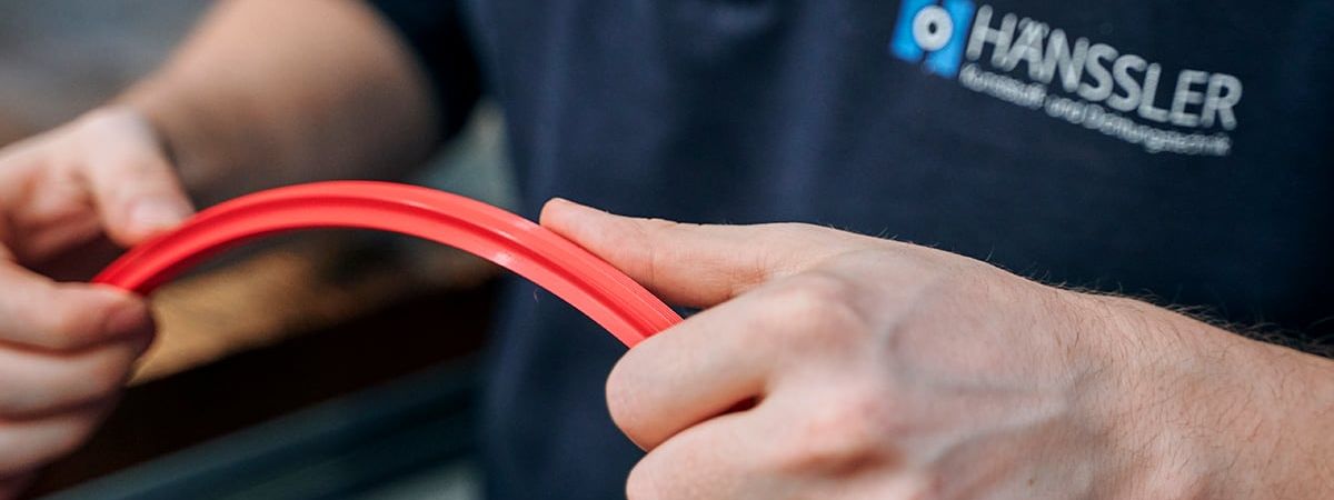 An employee checks a red part