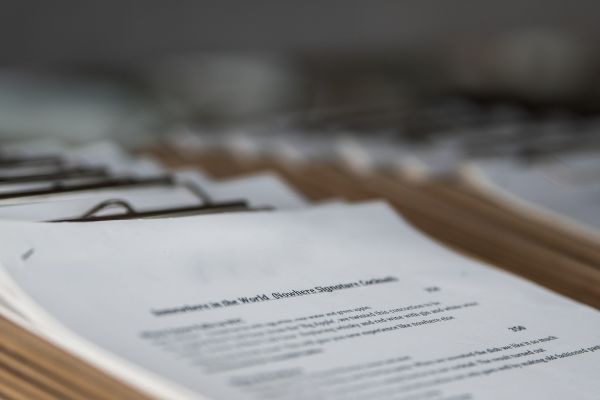 Several documents lie on top of each other on clipboards