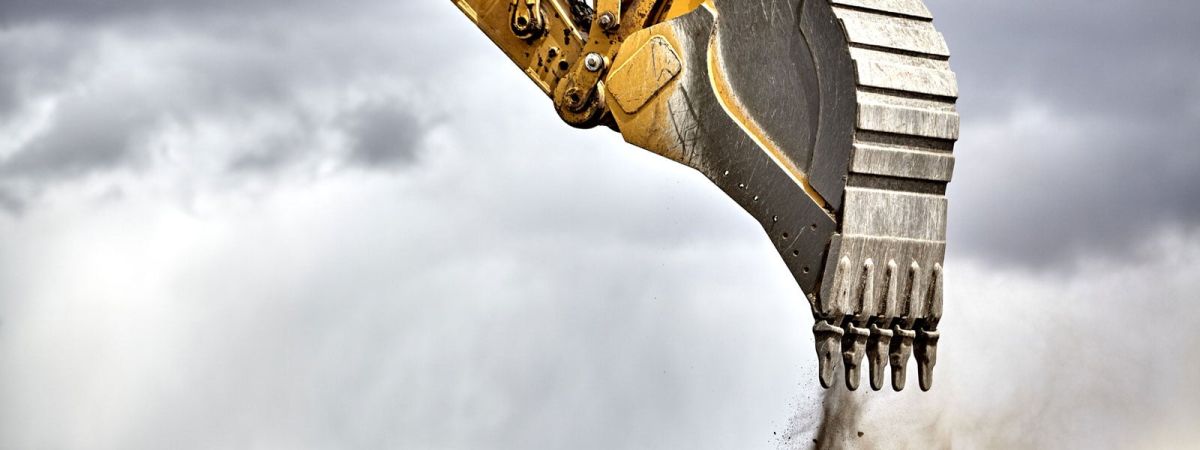 An excavator shovel drops its contents