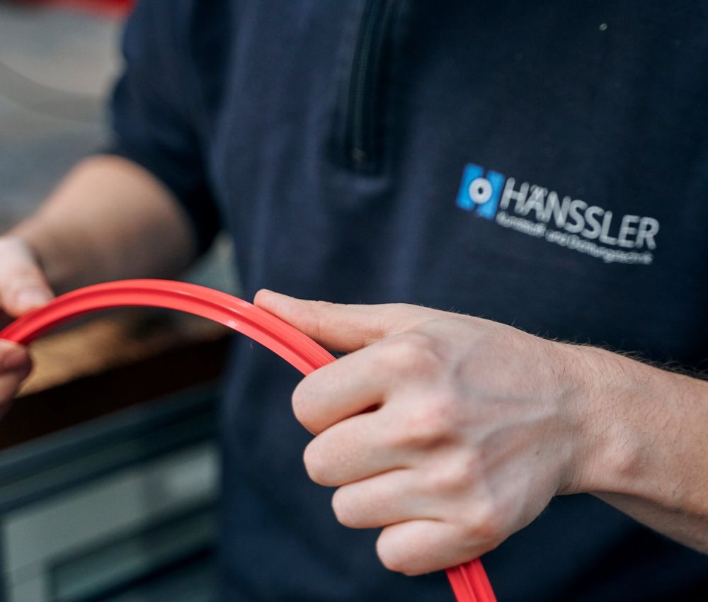 Employee holds large red sealing ring in his hand