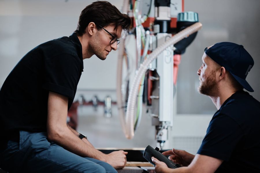 Two employees talking in front of the machine 
